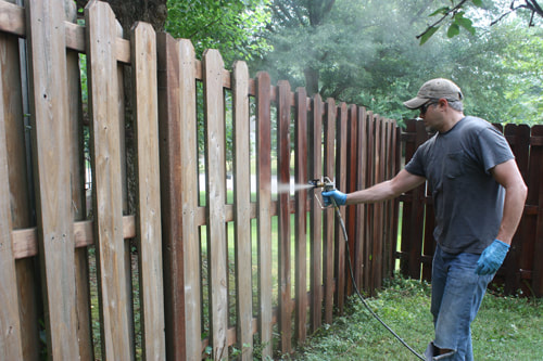 Staining a fence with a sprayer. This photo was taken in Mesquite, TX.